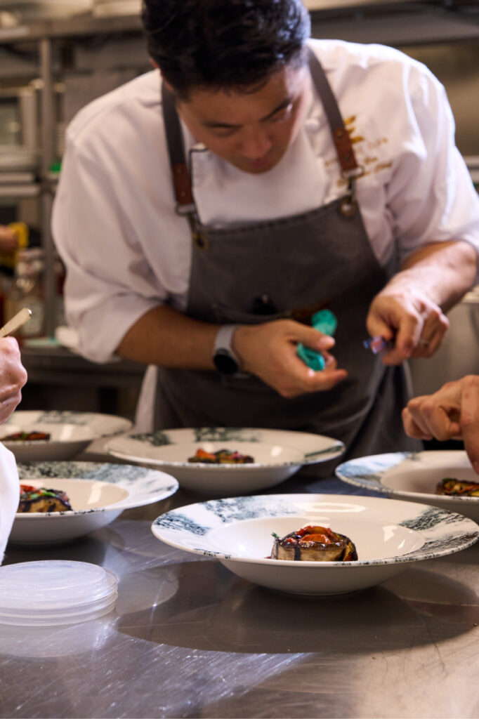 Chef Eric Um adds final touches to plated dinner entrées at Eau Claire Exchange Restaurant & Bar.